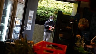Students from the Free University of Brussels wait in a line to pick up products at the Frigo Partage food bank in Brussels on Monday, March 8, 2021