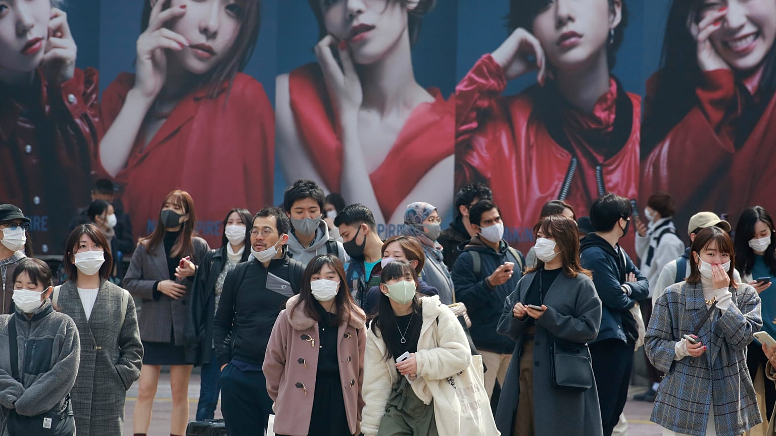 People wearing face masks to protect against the spread of the coronavirus wait at an intersection in Tokyo, Tuesday, March 9, 2021. (AP Photo/Koji Sasahara)