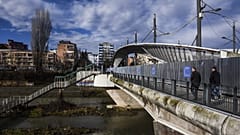 People walk on the main bridge of the town of Mitrovica on February 13, 2016.