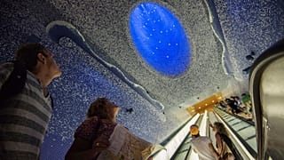 Tourists look at the ceiling of Toledo underground metro station in Naples by Spanish architect Oscar Tousquets Blanca.