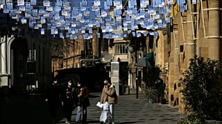 Περαστικοί στην πλατεία Φανερωμένης στην Λευκωσία που έχει σημαιοστολιστεί ενόψει των εορτασμών για τα 200 χρόνια από την Επανάσταση του 1821