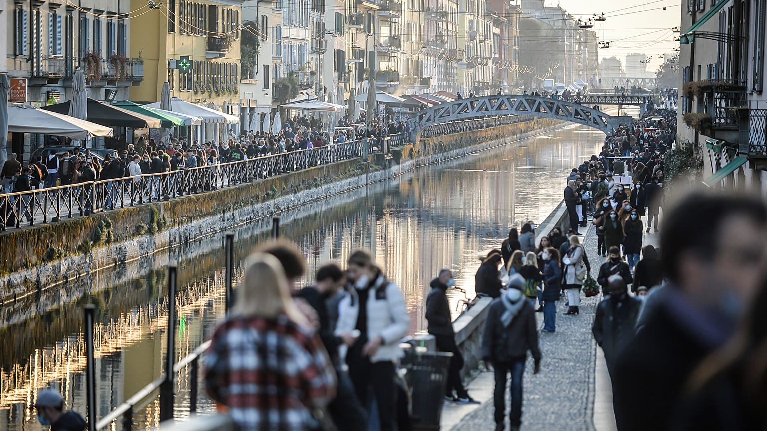 People stroll in the Navigli popular area Milan, Italy, Saturday, March 13, 2021.