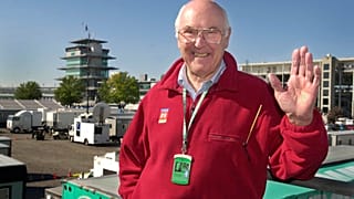 In this Sunday, Sept. 30, 2001 file photo, Legendary Formula 1 race broadcaster Murray Walker poses in the television compound at Indianapolis Motor Speedway.
