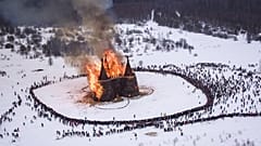 People watch a castle-shape wooden construction burning as part of celebrations at the Maslenitsa (Shrovetide) festival at the Nikola-Lenivets art park