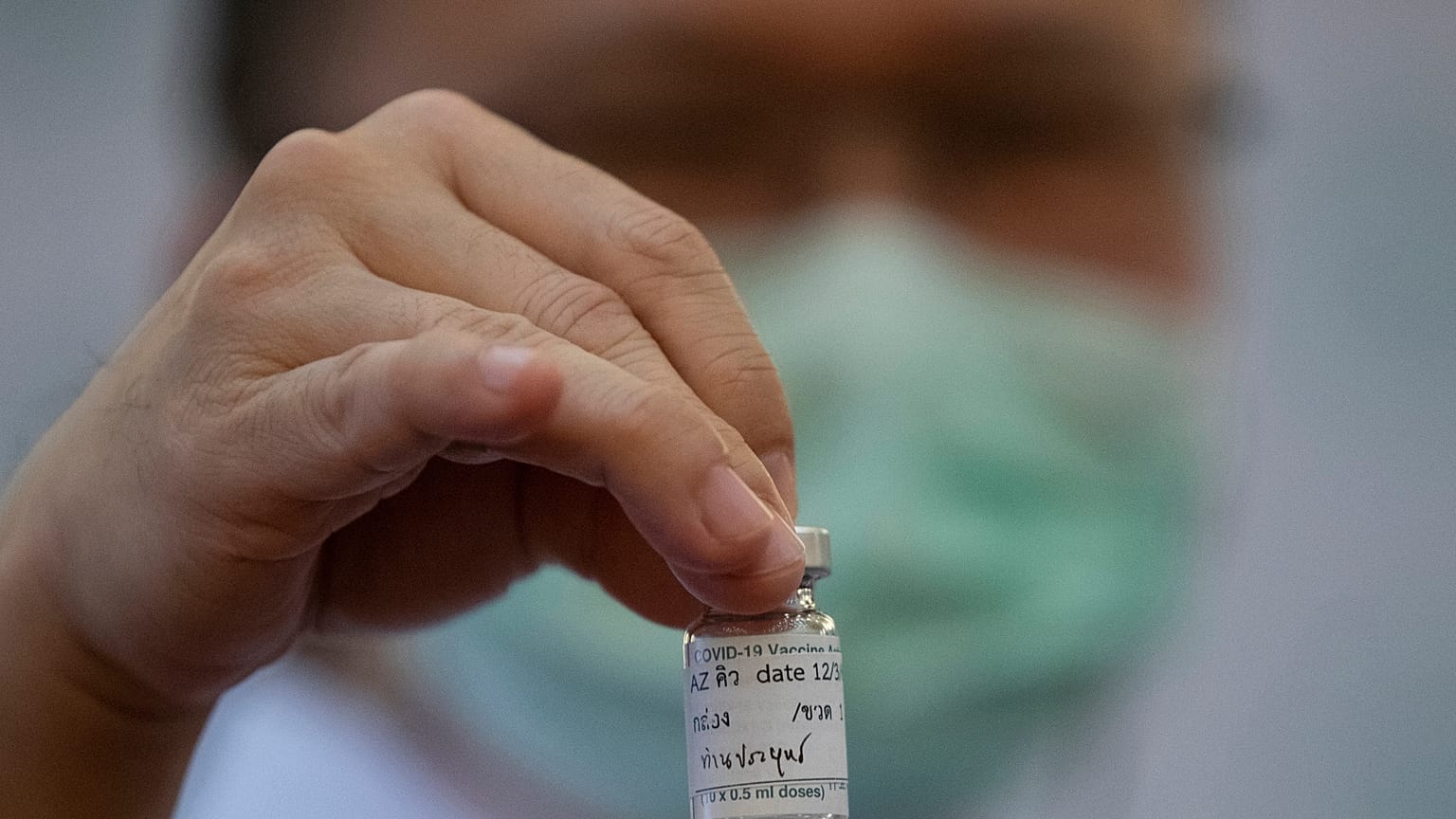 Медицинский работник держит бутылочку с вакциной AstraZeneca.