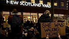 People hold signs outside New Scotland Yard during a march to reflect on the murder of Sarah Everard, in London, March 15, 2021. 