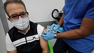 Doctor Khizer Hanif gives the AstraZeneca vaccine to a patient at a Pharmacy in Edgware, London, Tuesday, March 16, 2021.