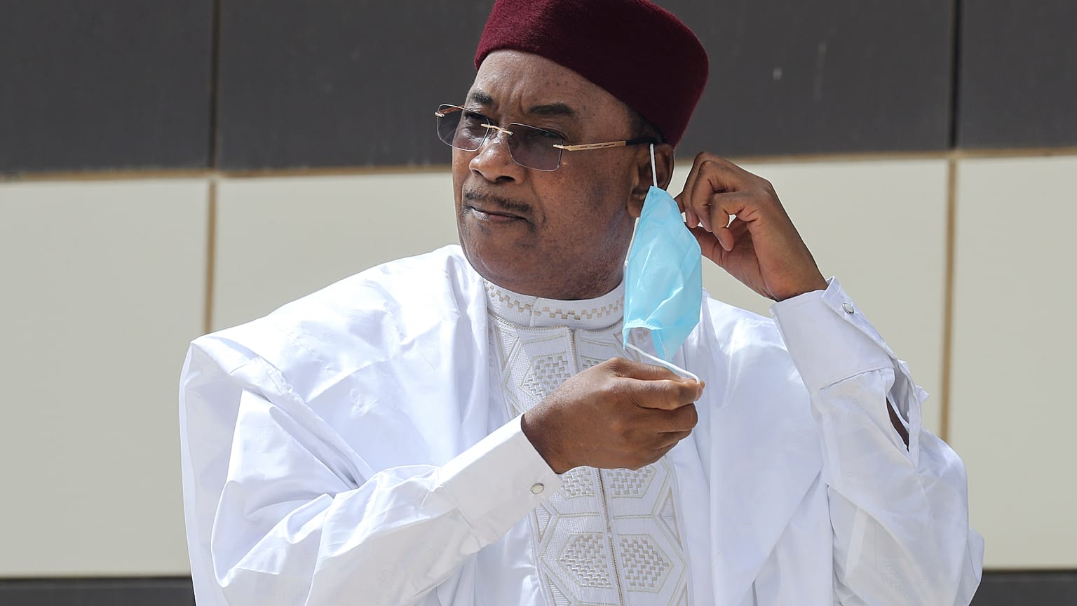 Niger President Mahamadou Issoufou takes off his face mask as he arrives for a group picture during the G5 Sahel summit, June 30, 2020, in Nouakchott.