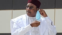 Niger President Mahamadou Issoufou takes off his face mask as he arrives for a group picture during the G5 Sahel summit, June 30, 2020, in Nouakchott.