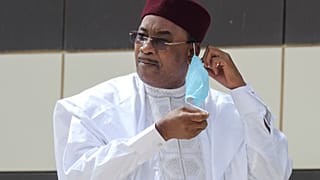 Niger President Mahamadou Issoufou takes off his face mask as he arrives for a group picture during the G5 Sahel summit, June 30, 2020, in Nouakchott.