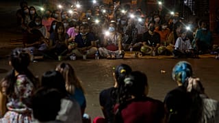Anti-coup protestors flash lights from their mobile phones during a rally in the Myaynigone area of Yangon.