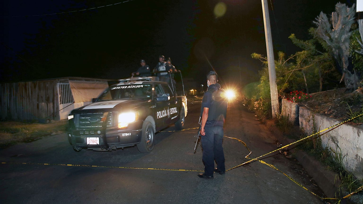Heavily armed state police officers near where 13 law enforcement officers were killed in central Mexico