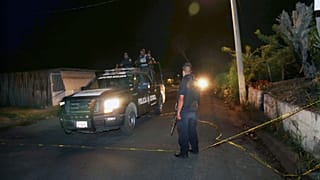 Heavily armed state police officers near where 13 law enforcement officers were killed in central Mexico
