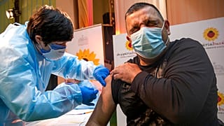 An Albanian nurse administers a AstraZeneca coronavirus vaccine to a Kosovo doctor in the northern Albanian town of Kukes on Saturday, March 20, 2021.