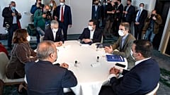 Greece's Prime Minister Kyriakos Mitsotakis, right, attends a ministerial meeting in Athens, Saturday, March 20, 2021.