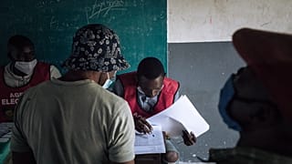 An electoral commission official checks the voters roll at a polling station in Brazzaville, Congo, on March 21, 2021.