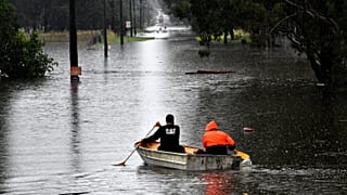 Residents commute via boat in a flooded residential area near Windsor, New South Wales.