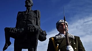 Солдат стоит у мемориального комплекса Хатынь.