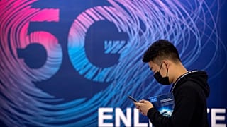 رجل يمر حذو لوحة إشهارية لخدمة 5جي في معرض في بيكين. 2020/09/14