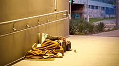 Ein Mann liegt in Budapest auf der Straße und raucht eine Zigarette.
