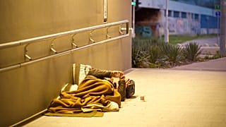 Una persona sin techo en la calle fumando un cigarrillo en Budapest, Hungría.