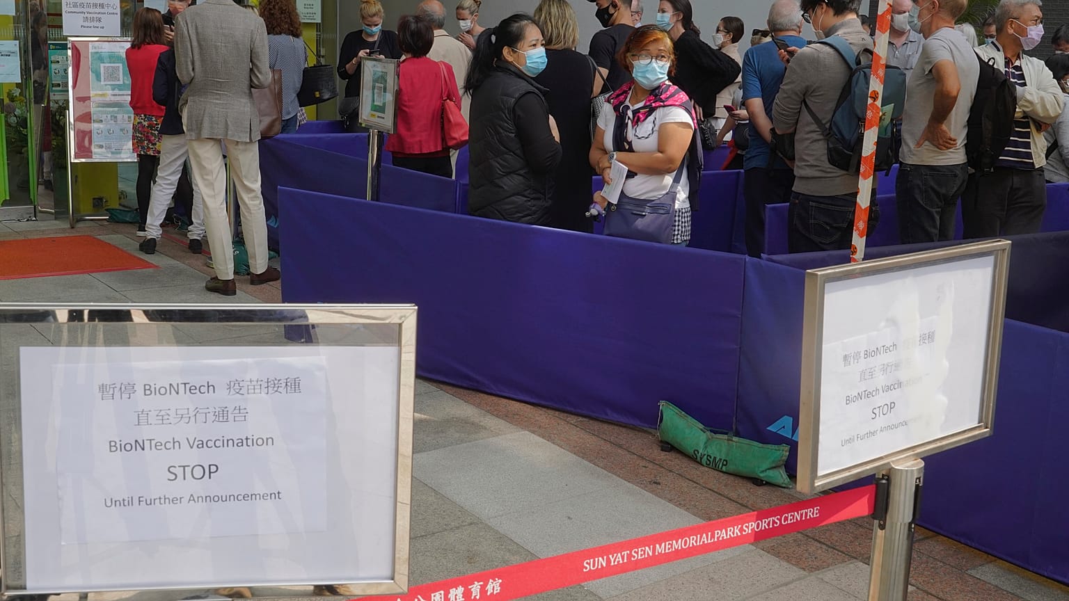 People queue up outside a vaccination center for BioNTech in Hong Kong Wednesday, March 24, 2021. 