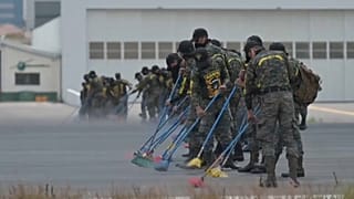 Militares con escobas limpian la ceniza del aeropuerto internacional de Guatemala