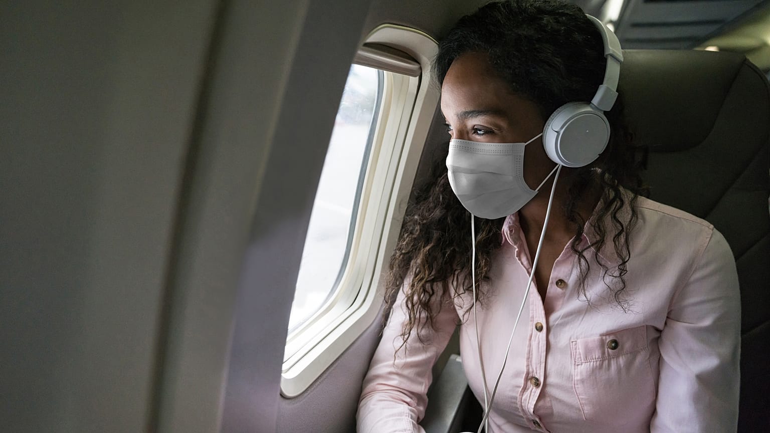A passenger looks out of a window on a plane