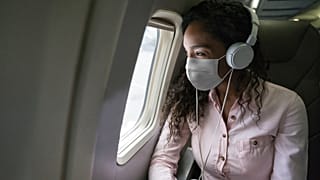 A passenger looks out of a window on a plane
