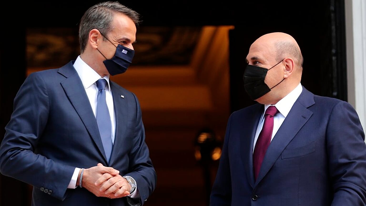 Greece's Prime Minister Kyriakos Mitsotakis, left, welcomes Russian Prime Minister Mikhail Mishustin at Maximos Mansion in Athens,