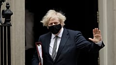 British Prime Minister Boris Johnson waves at the media as he leaves 10 Downing Street for the Houses of Parliament, in London, Wednesday, March 24, 2021. 