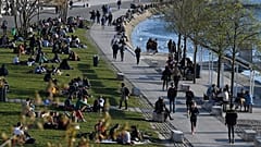 People take a break on a bank of the Rhône river in Lyon, south-eastern France, one of the new areas to have restrictions tightened,  on March 25, 2021. .