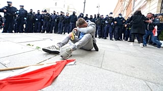 A man wipes his eyes after police used tear gas toward protesters demanding an end to economic restrictions during the coronavirus pandemic in Warsaw, Poland