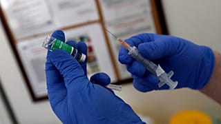 لقاح أسترازينيكا في يد أحد الممرضين في صربيا 