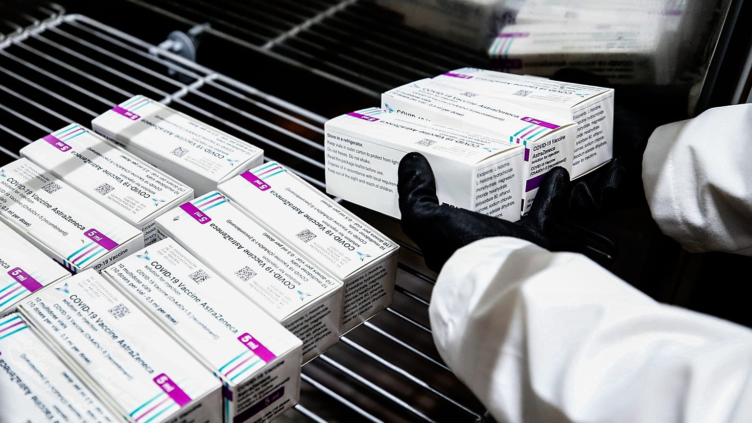 A health worker places packages containing doses of the AstraZeneca vaccine inside a fridge upon their arrival at a vaccination centre in Rome. February 9, 2021 