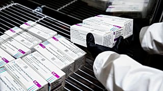 A health worker places packages containing doses of the AstraZeneca vaccine inside a fridge upon their arrival at a vaccination centre in Rome. February 9, 2021 