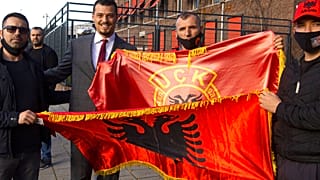 Endrit Thaci, third left, son of Hashim Thaci, poses outside the court building where Thaci is to face charges including murder, torture and persecution.