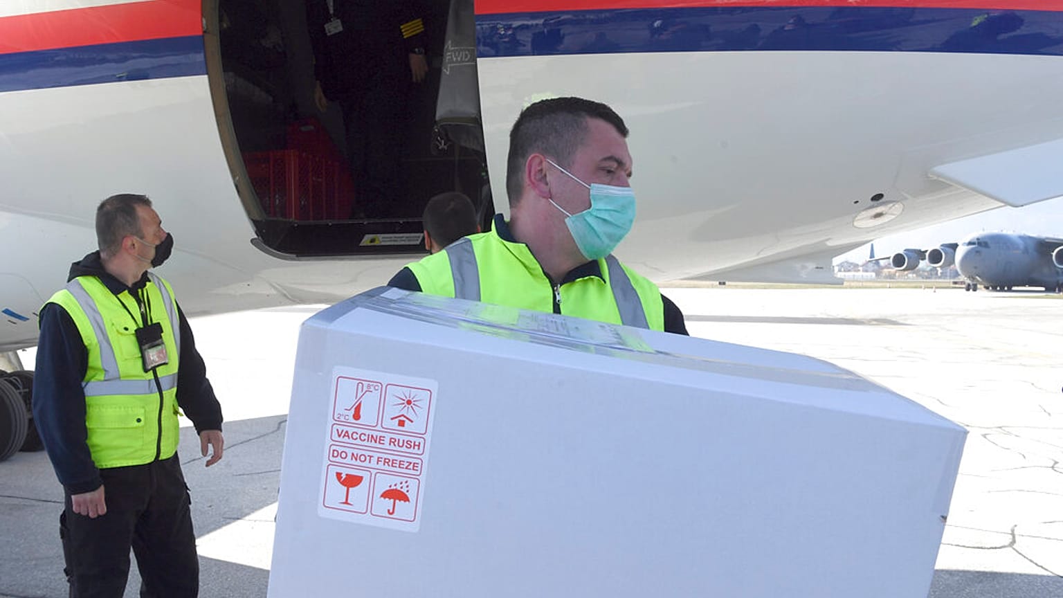 a worker holds a box of the Astra-Zeneca vaccines