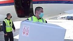  a worker holds a box of the Astra-Zeneca vaccines