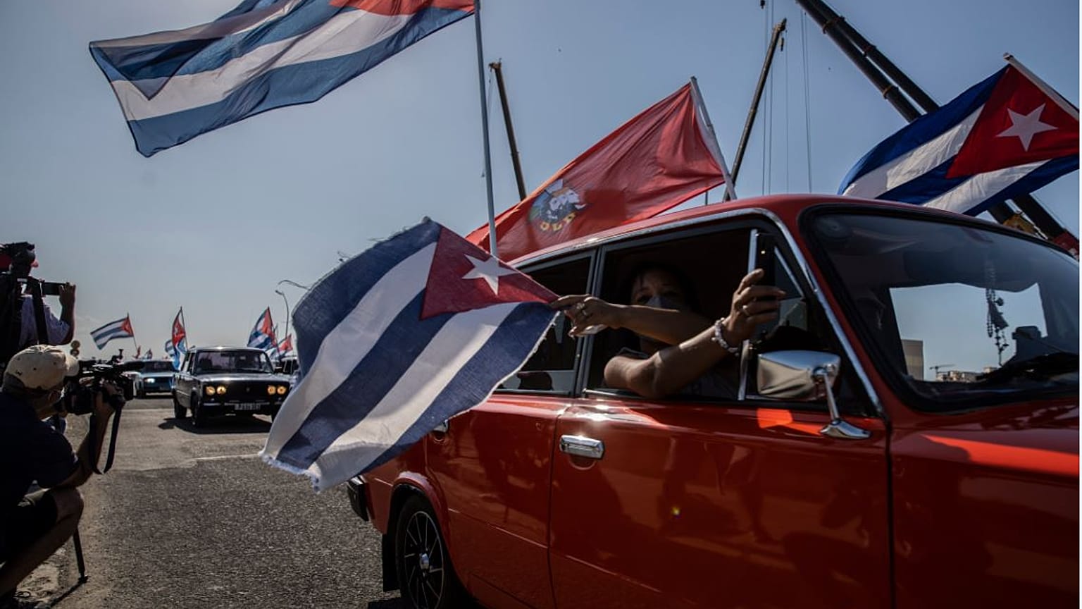 Gente con banderas cubanas en un Lada en La Habana