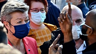 EU Commissioner Ylva Johansson, left, listens to an asylum seeker at a refugee camp in the port of Vathy on the eastern Aegean island of Samos, Greece, March 29, 2021.