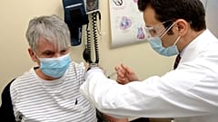 Nicole Picard receives a dose of the Moderna COVID-19 vaccine from pharmacist Nabil Chikh as pharmacies begin administering COVID-19 vaccinations Monday, March 22, 2021.