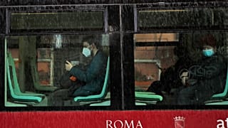 People wearing face masks to curb the spread of COVID-19, sit at distance in a tram in downtown Rome, Monday, March 15, 2021.