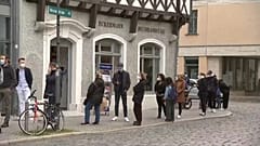 Menschen warten vor einem Geschäft in Weimar