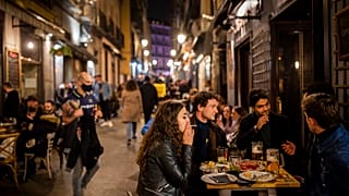 Tourists and locals have drinks at a bar in downtown Madrid, Spain, Friday, March 26, 2021.