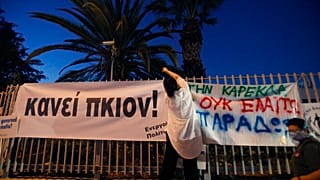 Διαδηλώτρια κρεμάει πανό που γράφει «Αρκετά»