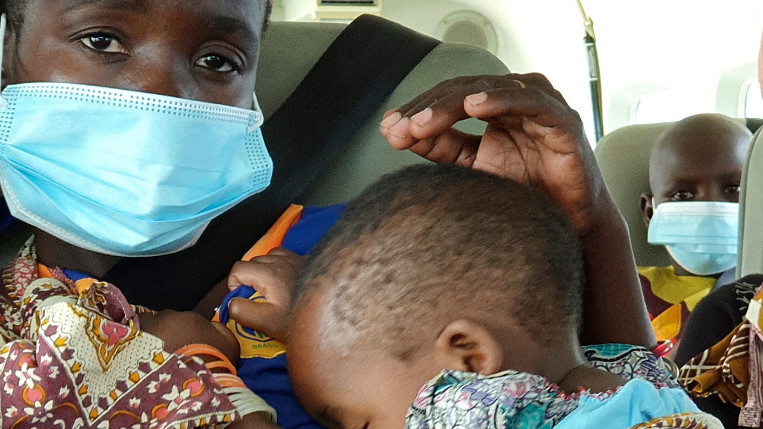 Uma mulher com uma criança ao colo é levada de avião de Palma para Pemba, em Moçambique