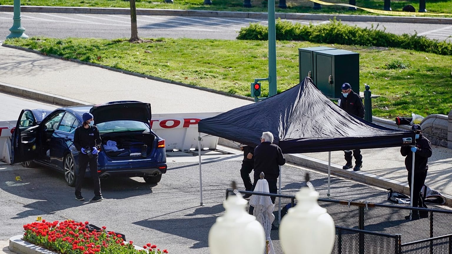 U.S. Capitol Police officers stand near a car that crashed into a barrier on Capitol Hill in Washington, Friday, April 2, 2021.