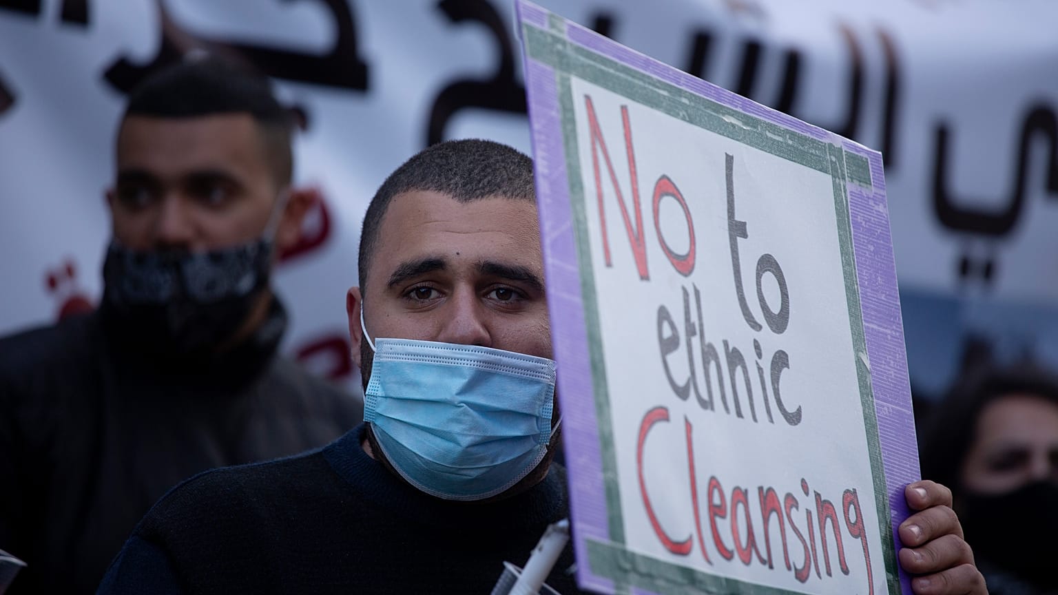 ملصق لا للتطهير العرقي يحمله فلسطيني في حي الشيخ جراح القدس.