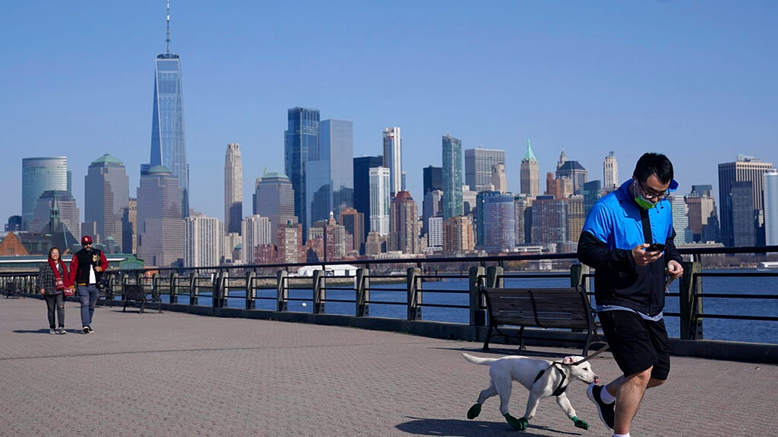 people enjoy the warming weather and a view of lower Manhattan at Liberty State Park in Jersey City